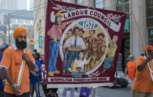 Man holding a Labour Council banner at the Labour Day parade.